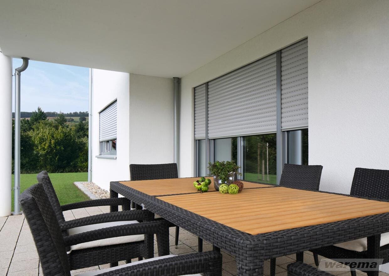 Abb. Einfamilienhaus Terrassenseite mit mehreren dreiviertel geschlossenen Rollladensystemen von Firma Warema