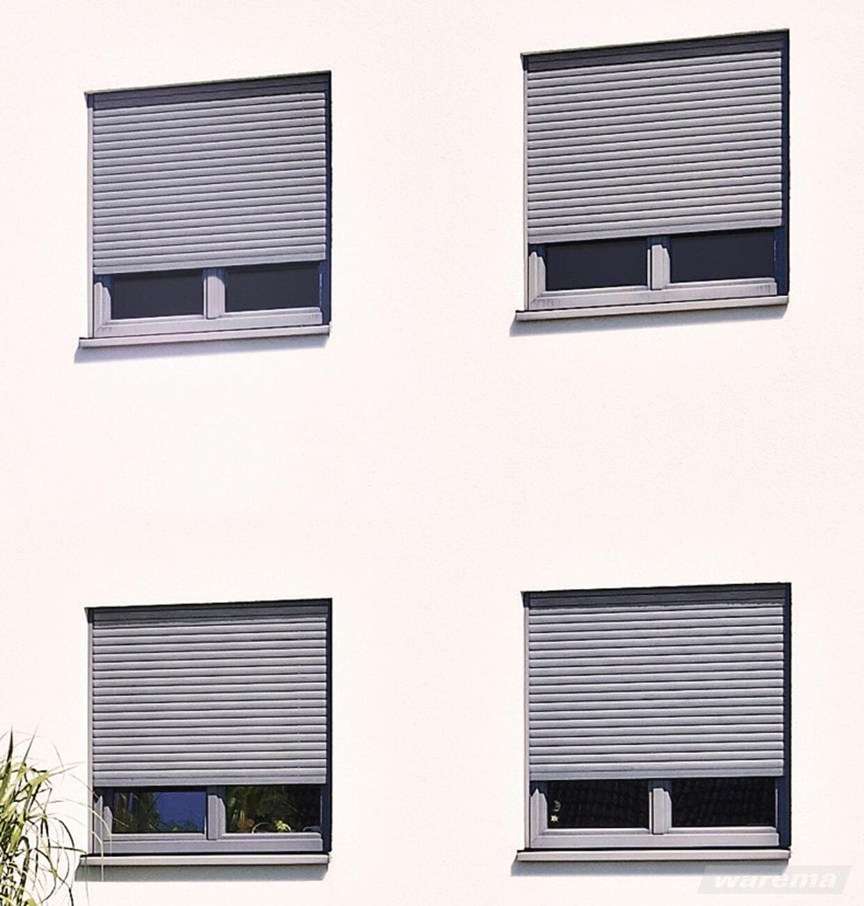 Abb. Mehrfamlienhaus mit 4 Fenster mit dreiviertel geschlossenen Rollladensystemen von Firma Warema